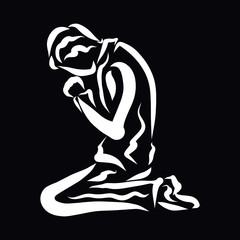 A man humbly praying to God on his knees, black background