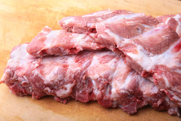 Raw Ribs on a rustic cutting board with salt, pepper and grinder for spices . copy space. Top View.