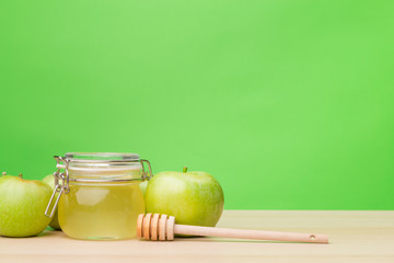 Jewish holiday Rosh Hashanah background with honey and apples on wooden table.