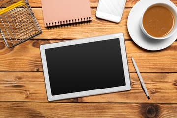 digital tablet and coffee cup on wooden table