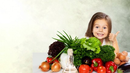 Fototapeta na wymiar Cute little girl with vegetables in kitchen
