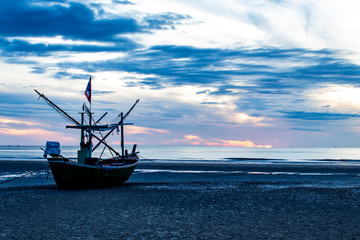 The morning sun light in the sea, and the boat on the beach.