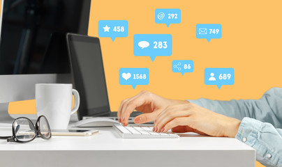 Young woman sitting at the table with open netbook computer. Female person using modern technology.