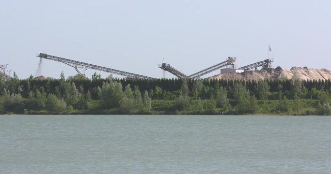 Sandpiles and conveyor, extraction of sand and gravel. Production site at Lingemeer near Echteld, The Netherlands.