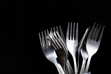 Lot of metal cutlery on a black background. Selective focus. Shallow depth of field