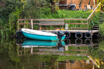 Fototapeta na wymiar Boat with a motor and oarss near the pier