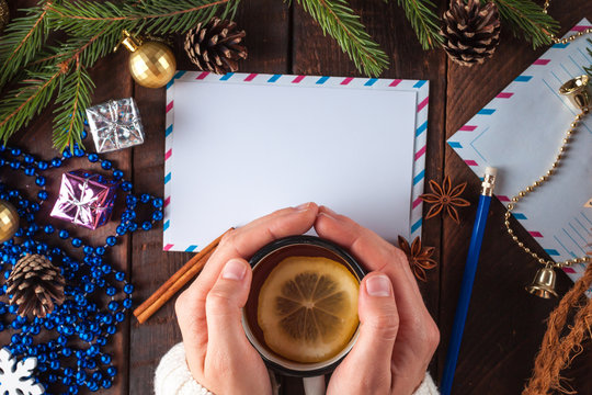 Christmas and New Year holidays. Spruce branch, cinnamon, anisee tree, cones, Christmas decorations, letter to Santa Claus and hot tea with lemon on a wooden background. Merry Christmas. Copy space