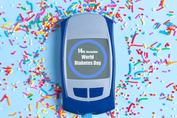 Diabets. Glucose meter and sweet powder on a blue background. World diabetes day, diabetes concept. 14 November