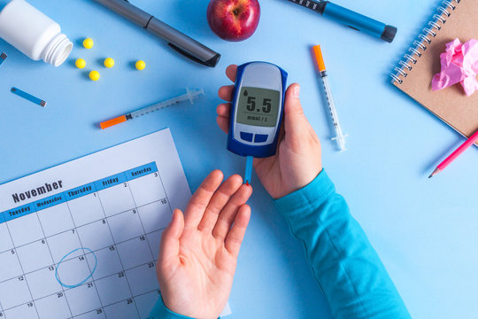 The diabetic measures the level of glucose in the blood. World Diabetes day, 14 November. Diabetes concept. Diabetic supplies on a blue background.
