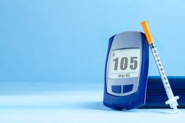 Diabetes. Diabetes concept. Glucose meter and injections for insulin on a blue background. Diabetic supplies. Copy space