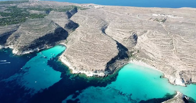 Aerial view of Spiaggia dei Conigli next to the island of Lampedusa, Sicily, Italy with Mediterranean sea. Italian summer landscape seen from the sky with drone flying over beach
