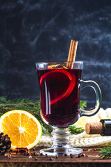 Mulled wine in a glass with citrus fruits and spices. Cozy, warm, winter evenings. Winter drinks. Christmas and New Year holidays.