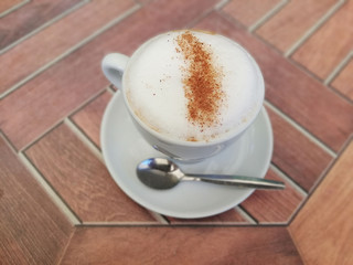 Cup of coffee with teaspoon on the table