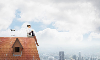 Businesswoman or accountant on house roof floating high above modern city. Mixed media