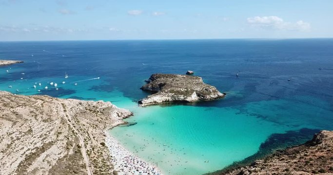 Aerial view of Isola dei Conigli next to the island of Lampedusa, Sicily, Italy with Mediterranean sea. Italian summer landscape seen from the sky with drone flying over beach