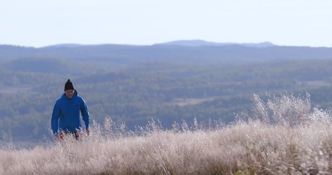 Adventurous young man walks in nature looking for some berries to pick.