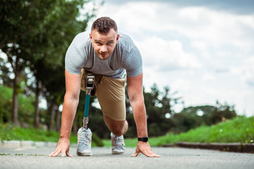 Confident young man with disability standing on the track