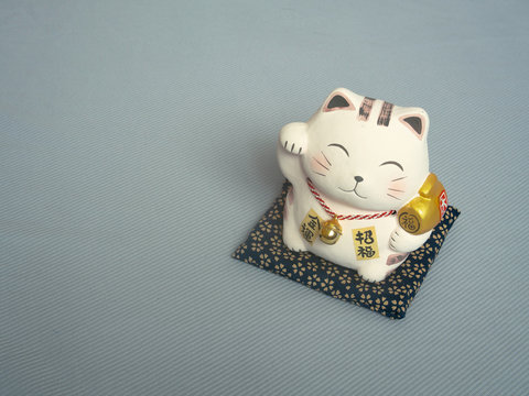 Lucky cat on fabric blue background.