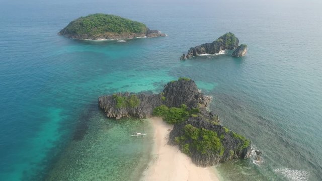 Aerial view islands with sand beach and turquoise water in blue lagoon among coral reefs, Caramoan Islands, Philippines. Landscape with sea, tropical beach.
