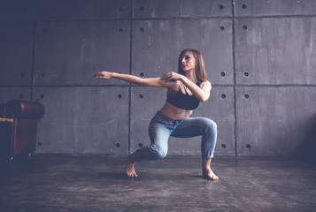 Fototapeta na wymiar young beautiful woman in top and jeans dancing modern contemporary dance in the studio, contemporary art, harmony of body and soul, professional dancer
