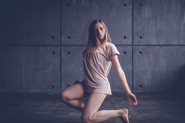 young beautiful woman professional dancer dancing during a rehearsal in a dance studio, modern dramatic style, experimental dance