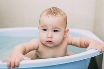 Girl having fun bathing in the bathroom in the basin