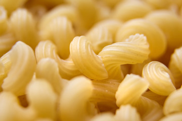 Heap of Uncooked Cavatappi Italian Pasta . Closeup, selective focus