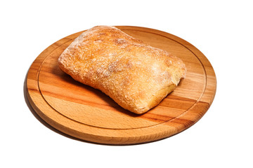 traditional italian wheat bread ciabatta lying on a wooden cutting board.   isolated on white background