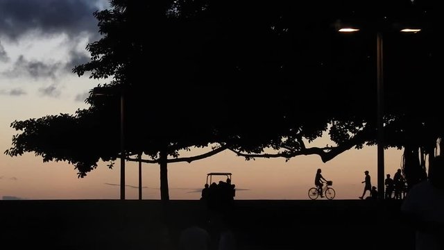 Two silhouettes biking after sunset in Honolulu on the island of Oahu,Hawaii.