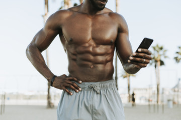 Obraz premium Fit man listening to music while at the beach