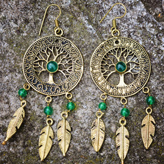 Indian spiritual ornamental style brass earrings on rocky background