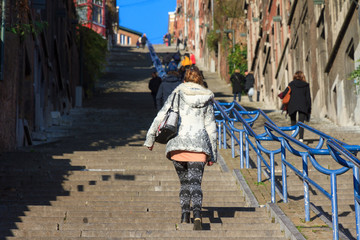 Beautiful young woman climbs the 374-step long staircase Montagne de Bueren, a popular landmark and tourist attraction in Liege, Belgium