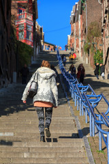 Fototapeta na wymiar Beautiful young woman climbs the 374-step long staircase Montagne de Bueren, a popular landmark and tourist attraction in Liege, Belgium