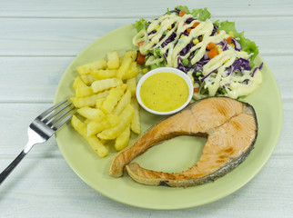 Salmon steak and Knife with fork on a black rock background , Top view with copy space for your text..