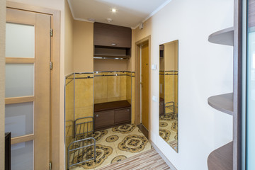 Interior of the flat. Warm tones, wooden floor. Hallway furniture.