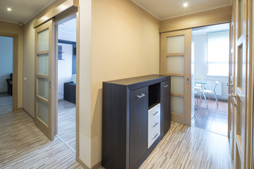 Interior of the flat. Warm tones, wooden floor. Hallway furniture.