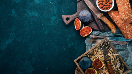 Figs on a wooden board. Slice figs. On a dark background. Free space for text. Top view.