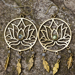 Indian spiritual ornamental style brass earrings on rocky background