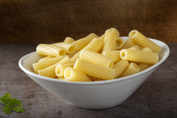 Boiled rigatoni pasta in a white bowl