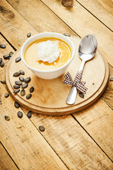 fresh and delicious pumpkin soup on an old wooden kitchen table