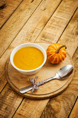 fresh and delicious pumpkin soup on an old wooden kitchen table