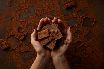 cropped shot of delicious chocolate pieces in human hands