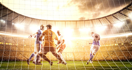 Intense soccer moment in front of the goal on the professional soccer stadium.