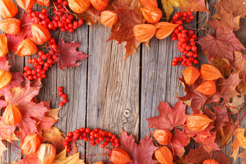 Autumn pattern golden maple leaves on wooden background