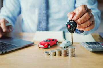 car dealer hand holding key. concept car insurance and financing