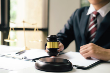 Male lawyer in the office with brass scale..
