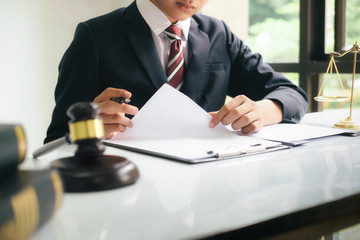 Male lawyer in the office with brass scale..