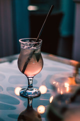 Two glasses of cocktail in the cafe with bright lights on the mirror table in the evening