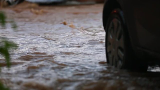 The car moves along a flooded road. Slow motion.