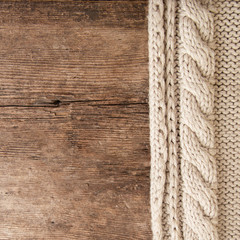 texture of a beige knitted sweater on a wooden background. knitted, close-up